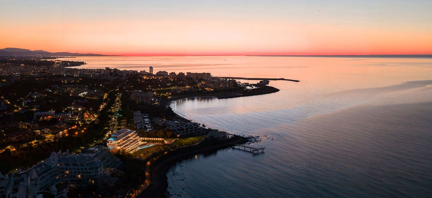 The coast at sunset, with the building on the water